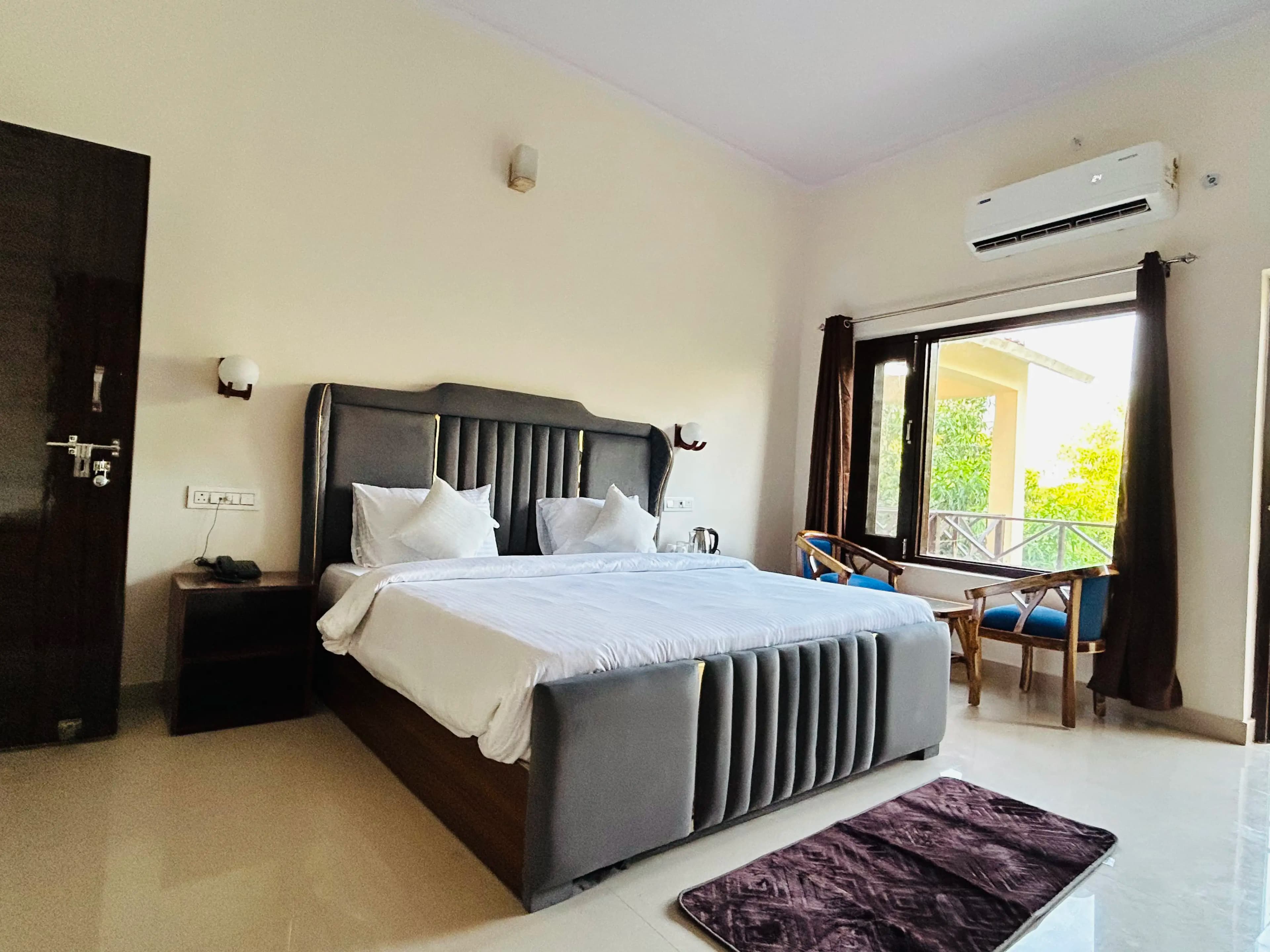 Spacious Bedroom with sitting chairs & air conditioning